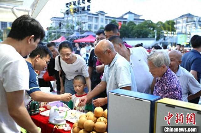 游客市民在活动现场试吃连州水晶梨。谭家富 摄
