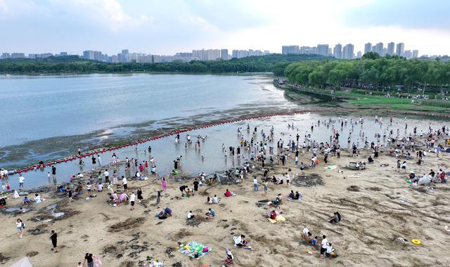 天气炎热，郑州北龙湖沙滩成热门景点