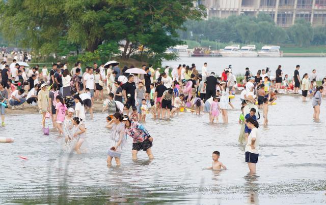 天气炎热，郑州北龙湖沙滩成热门景点