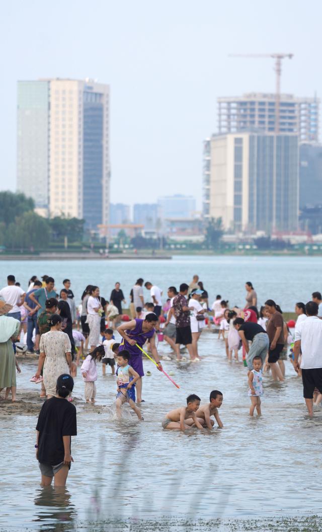 天气炎热，郑州北龙湖沙滩成热门景点