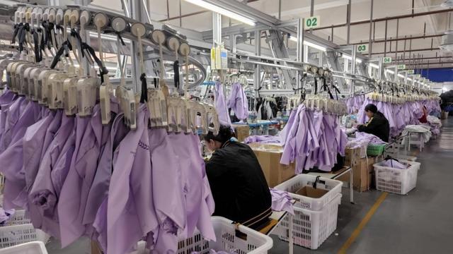 江西万马智能服饰有限公司生产车间,工人正在忙碌。澎湃新闻记者 罗振宇 图