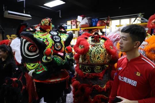 马大醒狮团仓库,刘佳峰向记者介绍狮头含义。 本报记者 宦翔 摄