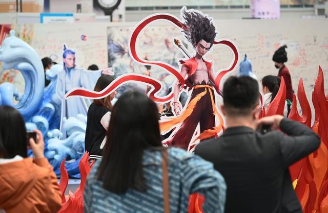 4月19日,观众在电影《哪吒之魔童闹海》破亿手绘海报展上参观拍照。新华社记者李鑫 摄