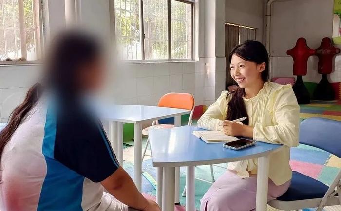 笑容明媚的张雅婷(图右),在为学生进行心理辅导。