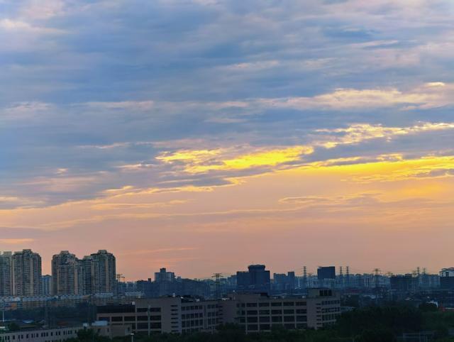 今晨，瑰丽霞光穿透云层，北京出现绝美丁达尔光