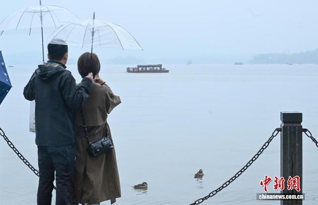 3月24日，游人在西湖边欣赏风景。中新社记者 王刚 摄
