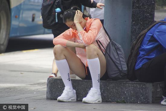 朱婷埋头坐路边状态疲惫 图片来源:视觉中国