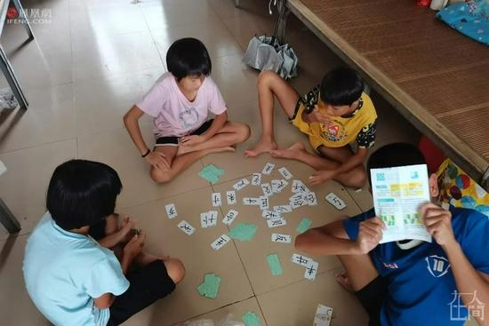 ■ 不同年龄的孩子们在宿舍里玩拼字牌。