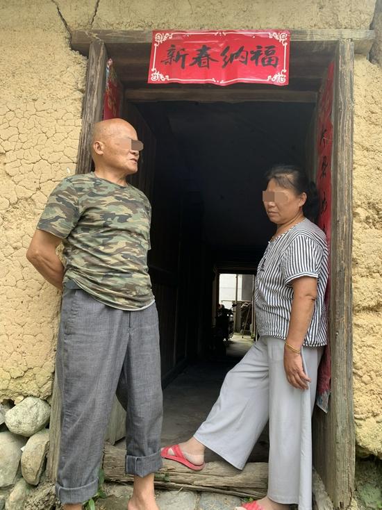 朱恒仁和徐玫枝倚着老宅的门,接受采访
