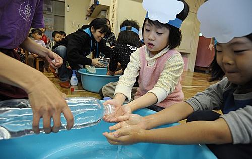 在日本横滨的中屋敷幼儿园,孩子们在学习完洗手操后洗手。(新华社)
