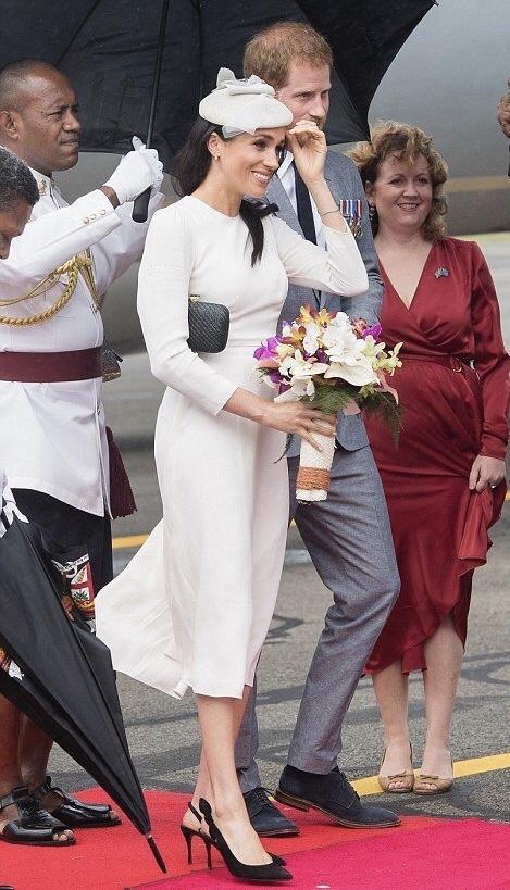 梅根王妃真有“女王”范，身穿酒红上衣搭配红棕短裙，时髦大气