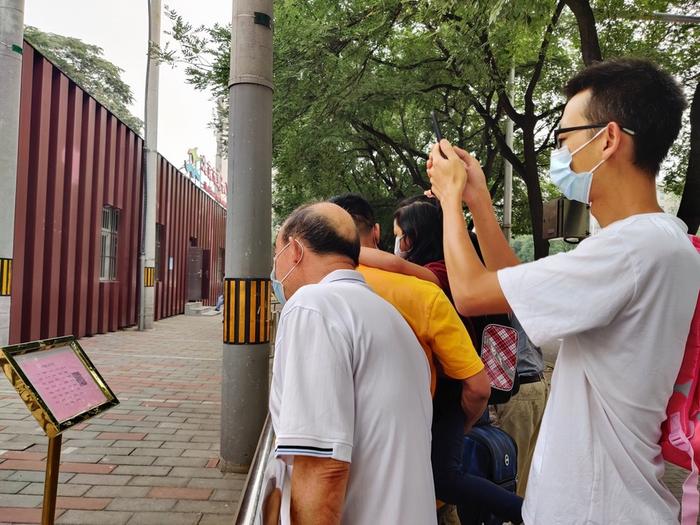北京十八中附属实验小学门前,家长们在通过指示牌确认孩子所属班级。