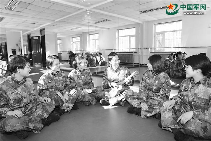图为连队干部和文艺骨干交流乐器使用。常桂苹摄