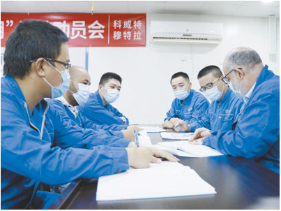 李朝辉(右二)带领的穆特拉新城项目工程技术团队与外籍工程师一起讨论施工细节。 中国能建葛洲坝集团供图