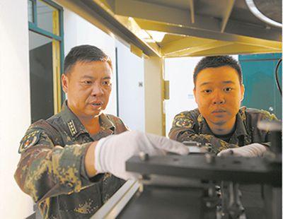 佘建斌和儿子佘立明一起探讨装备接收要点。肖兵 摄