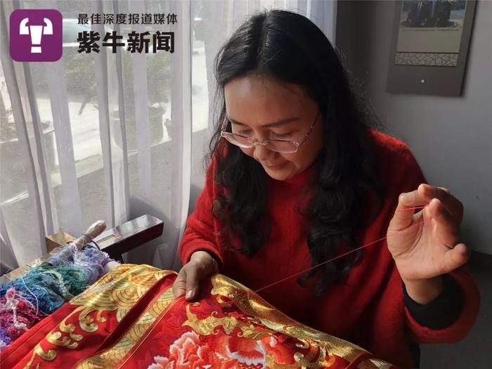 卢梅红戴上眼镜,一针一线地刺绣