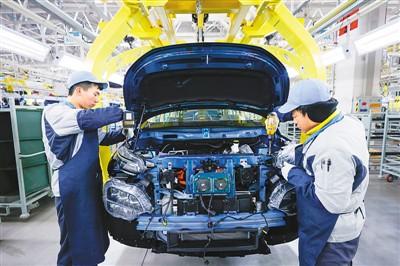 山西运城大运集团新能源汽车项目全部建成达产后,可形成年产2万辆纯电动商用车和10万辆纯电动乘用车的生产能力。图为12月14日,工作人员在总装车间作业。 闫 鑫摄(人民视觉)