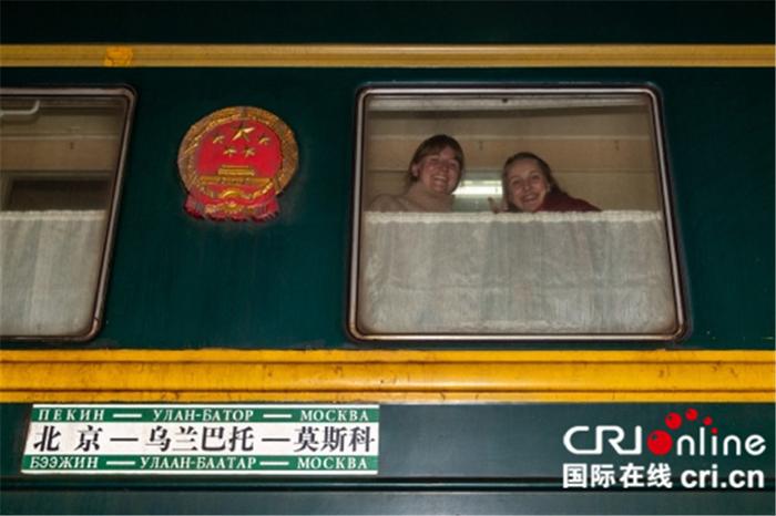 两位外国旅客向车窗外打招呼。摄影:沈湜