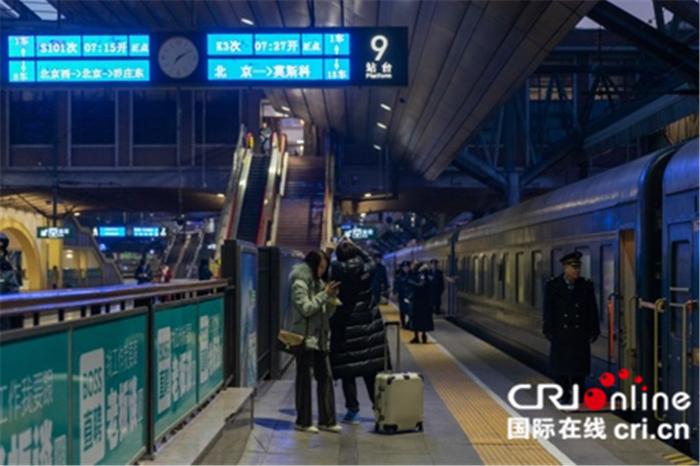 旅客在站台上拍照留念。摄影:沈湜