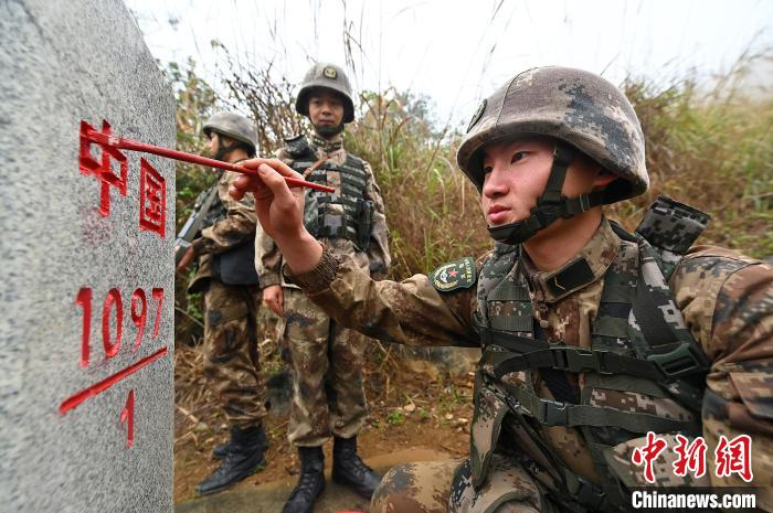 图为2000年出生的新兵曾森洲为1097号界碑上的“中国”二字描红。 俞靖 摄