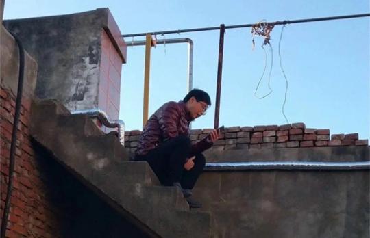 商丘师范学院教师范况生在济源老家,爬上屋顶给学生上网课。 范况生供图