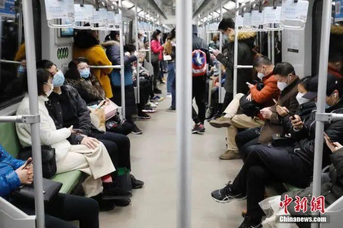 2月28日,乘客戴着口罩乘坐上海地铁出行。近日,随着上海企业全面复工,上海地铁客运量回升,高峰时段车厢满载率平均在五成左右。中新社记者 殷立勤 摄