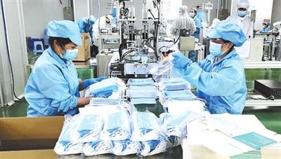 深圳一家企业的工人在口罩生产线上包装产品。新华社发