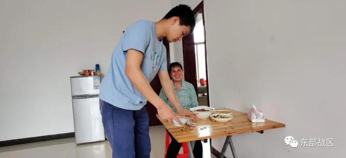 ▲吃完饭后,刘春洋在收拾桌子,母亲看了直乐。