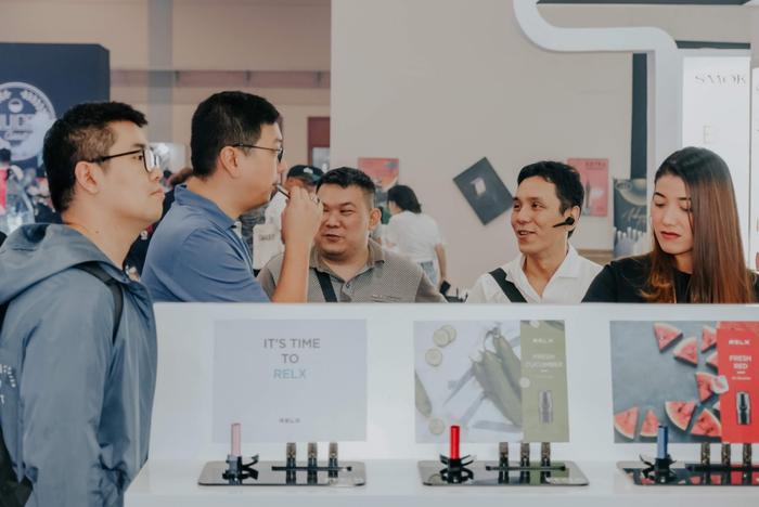 (在当地的电子烟展会上,悦刻吸引了不少商务人士。)