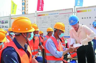 5月31日,中铁上海工程局法务工作者走进安徽肥西县人才公寓项目工地,为外来务工人员发放维权知识手册。 新华社发