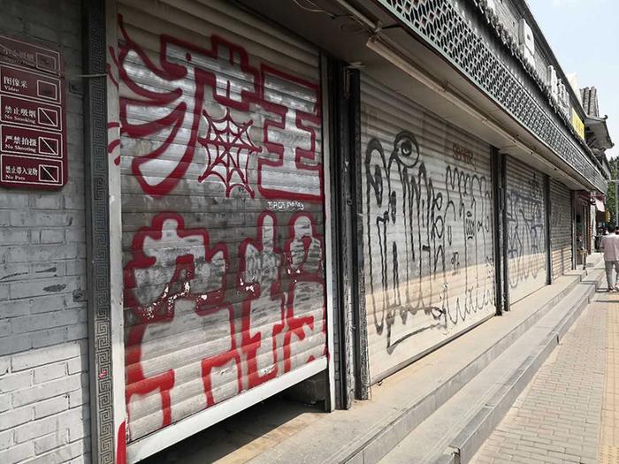 安定门内大街停业店铺大门上的涂鸦。 李凯旋摄
