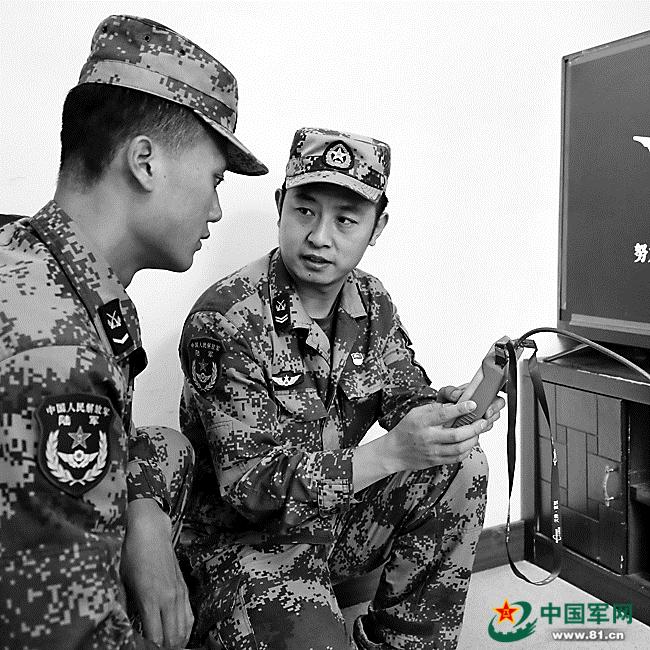 罗朝武(右)正在给“徒弟”何向向传授电视信号调试检测方法。王聪 摄