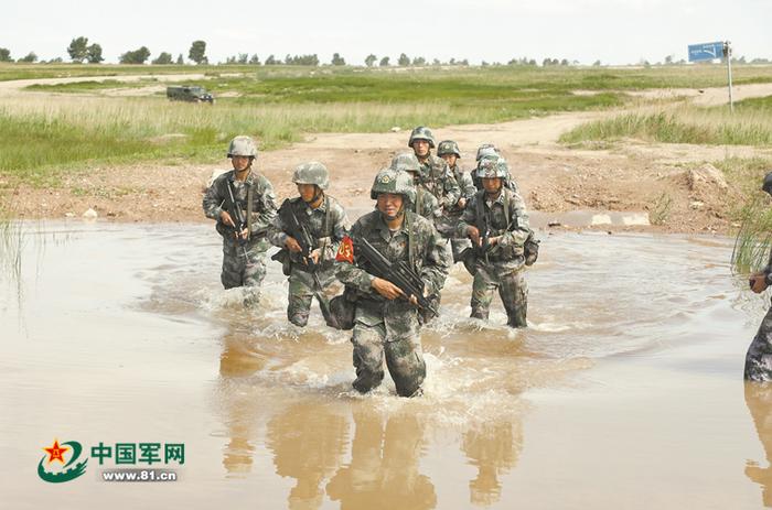 北部战区某部修理连二级军士长韩曦在班组战术考核时,带领班级人员通过涉水路面。刘常春摄