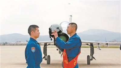 空军飞行教员王文常(右一)向徒弟徐国桥移交飞行头盔。周星宇 摄