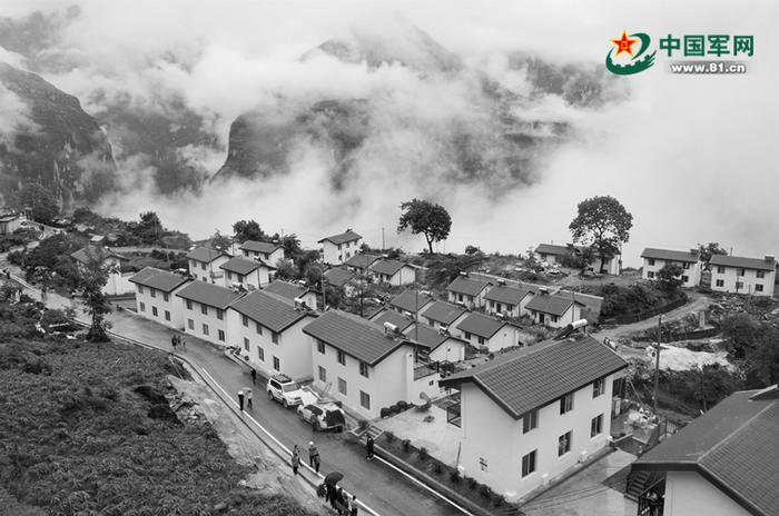 阿布洛哈村通村公路和公路旁的易地扶贫集中安置点。新华社记者 江宏景摄