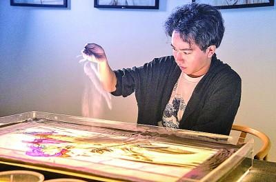 沙画创作者方俊华在创作沙画。光明图片
