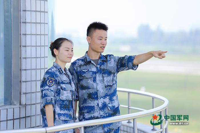 两人在塔台上眺望远方。