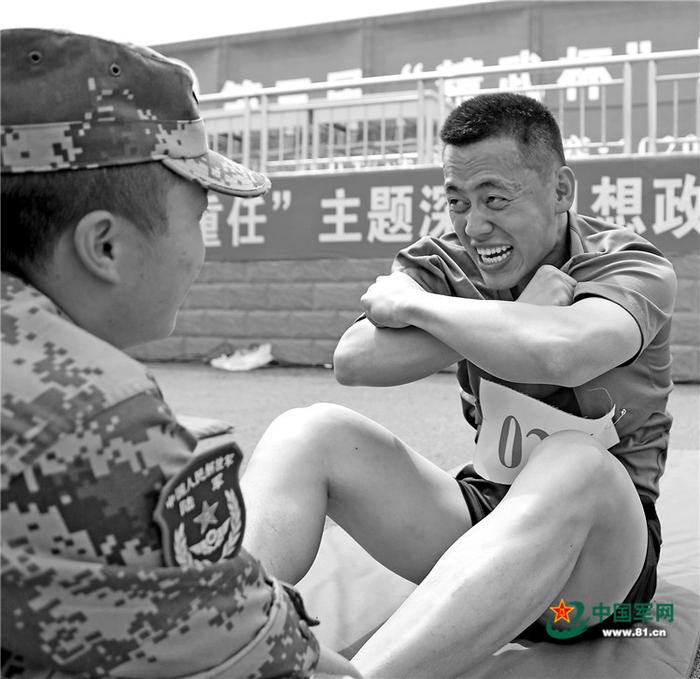 盛夏,新疆军区某训练基地组织“精武杯”军体运动会,文职人员踊跃报名。图为文职人员张丰铄(右)正在参加仰卧起坐比赛。罗兴仓摄
