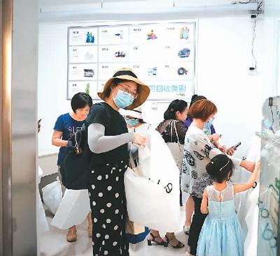 北京市朝阳区慧谷阳光小区居民在奥北再生资源回收站里领取袋子。 本报记者 彭训文摄