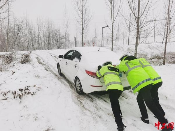 雪天坡高路滑车难行 交警秒变“推车侠”助脱困