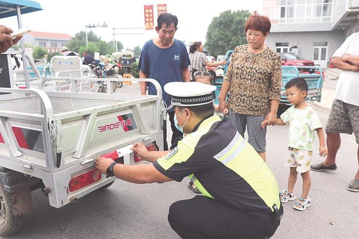 海兴交警深入农村集市为过往农用三轮车粘贴夜间反光条