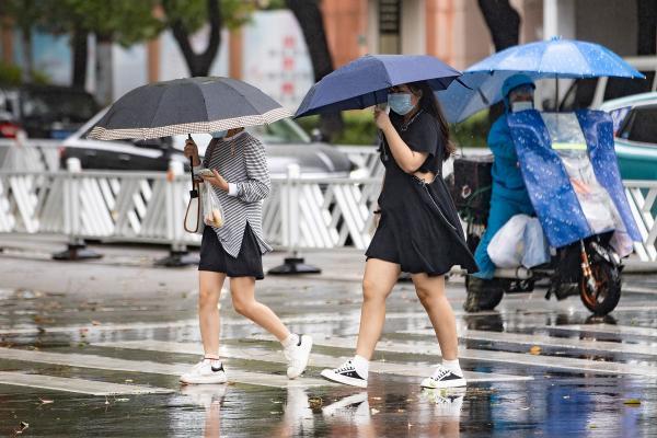 台风“轩岚诺”影响上海最强时段已经到来，市民冒雨出行