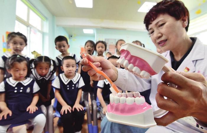 图为医护人员给小朋友们讲解正确的刷牙方法