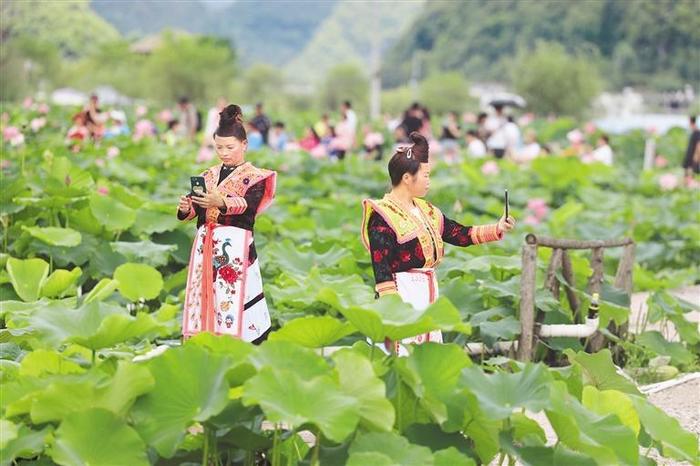 2022年，游客身着少数民族服装在安顺市十里荷廊景区拍照。