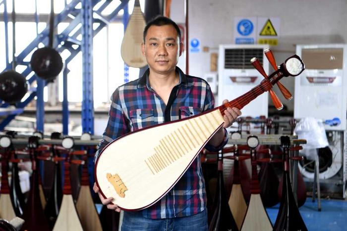 乐之洋乐器制造有限公司工人在展示琵琶成品。