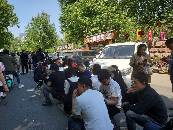 ↑“五一”假期第二天,在八大局便民市场附近一烧烤大院门前,人们排队等候进场 图据视觉中国