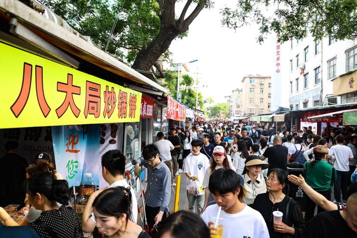 2023年5月1日,在山东省淄博市张店区八大局便民市场内,游客排队购买炒锅饼。图据ICphoto