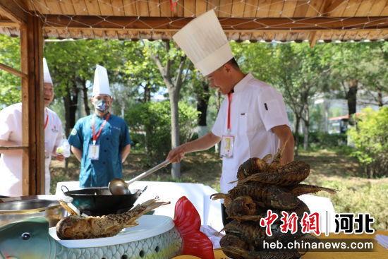 参加活动的餐饮企业在摊位上制作美食。 秦晶晶 摄