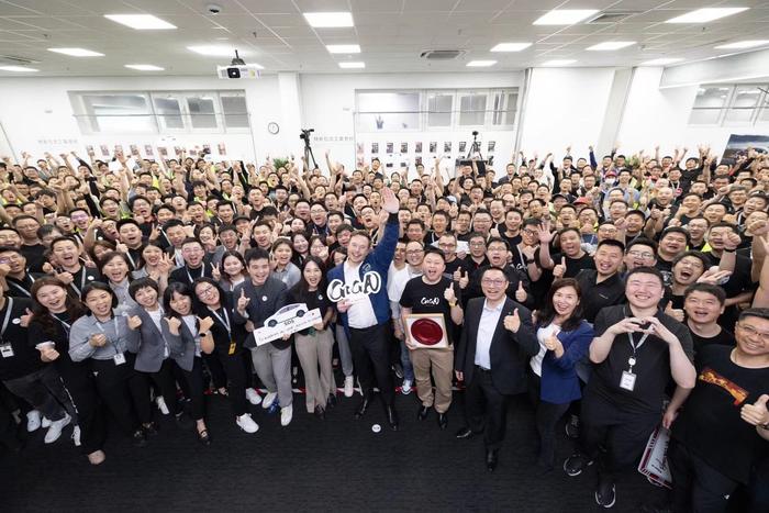 马斯克在超级工厂与员工合影。(图源:新浪微博)