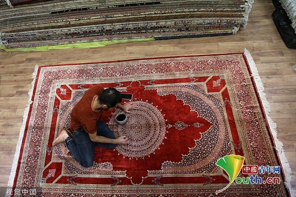 伊朗工人修复手工编织地毯